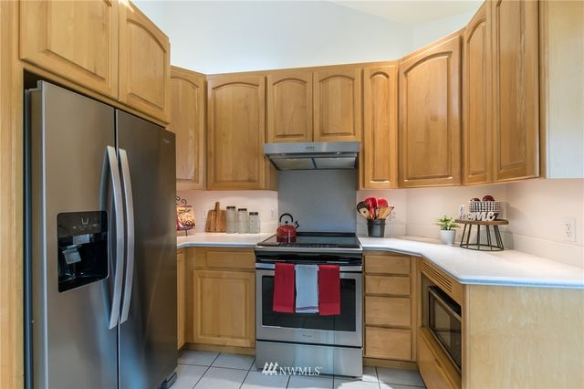 a kitchen with stainless steel appliances a refrigerator a sink and cabinets