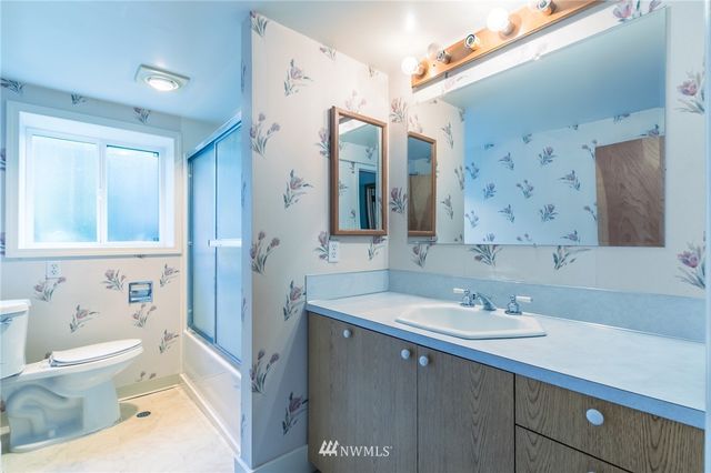 a bathroom with a sink a toilet and a mirror