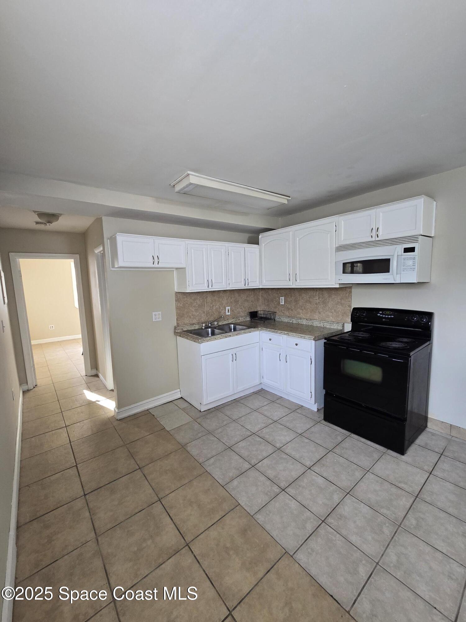 2320 Shenandoah Road, Unit A Palm Bay, FL 32905 - Photo 4 of 11 a kitchen with stainless steel appliances granite countertop a stove a sink and a refrigerator