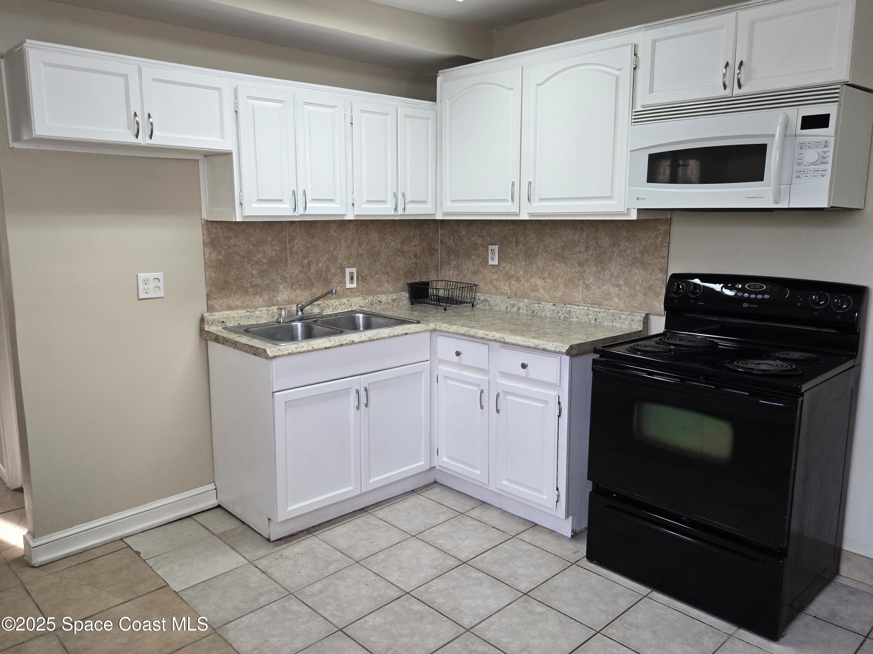 2320 Shenandoah Road, Unit A Palm Bay, FL 32905 - Photo 5 of 11 a kitchen with granite countertop white cabinets and stainless steel appliances