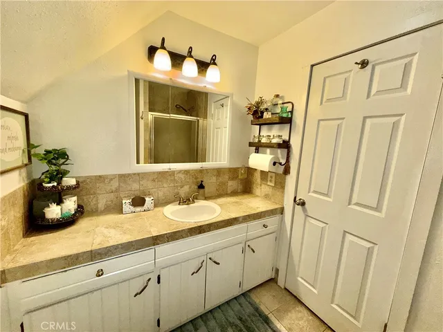 a spacious bathroom with a double vanity sink a mirror and a shower
