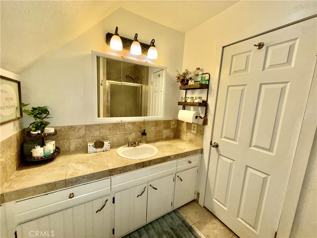 9312 Mountain Meadow Road Shingletown, CA 96088 - Photo 12 of 44 a bathroom with a double vanity sink and mirror