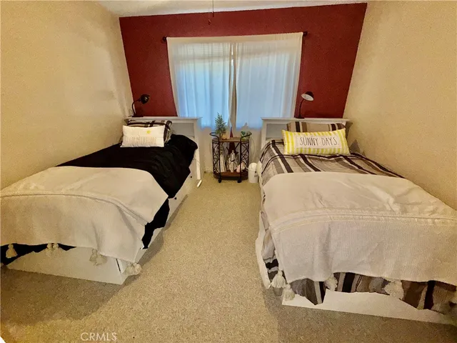 a bed sitting in a bedroom next to a window