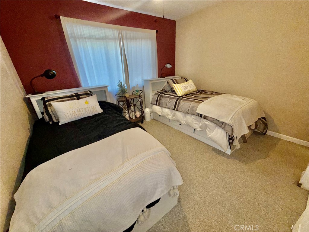 9312 Mountain Meadow Road Shingletown, CA 96088 - Photo 16 of 44 a bed sitting in a bedroom next to a window