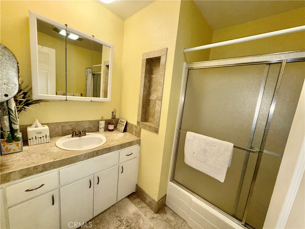 9312 Mountain Meadow Road Shingletown, CA 96088 - Photo 20 of 44 a bathroom with a sink a mirror and a shower