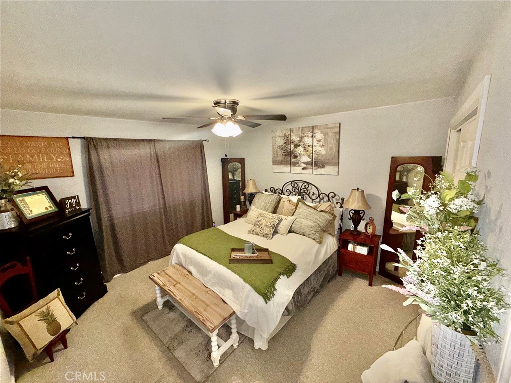 9312 Mountain Meadow Road Shingletown, CA 96088 - Photo 23 of 44 a bedroom with a bed and a chandelier
