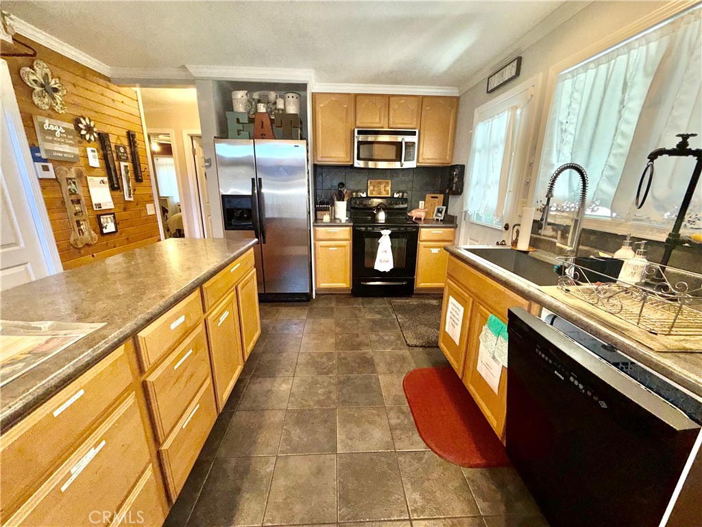 9312 Mountain Meadow Road Shingletown, CA 96088 - Photo 27 of 44 a kitchen with stainless steel appliances granite countertop a sink stove and refrigerator