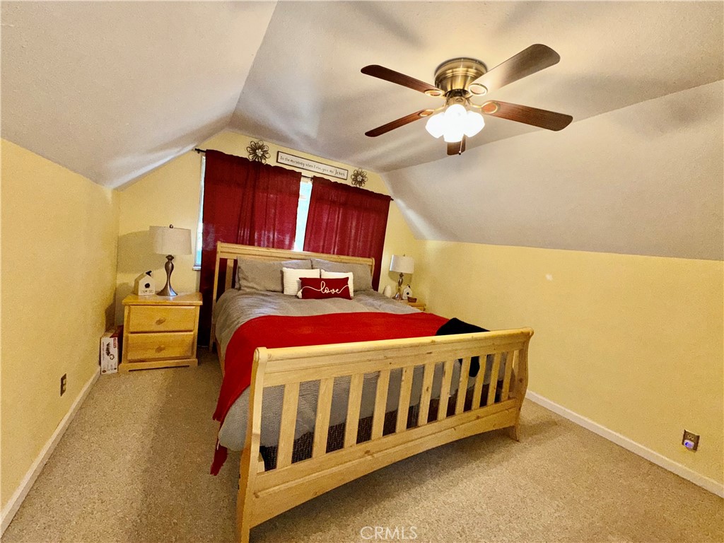 9312 Mountain Meadow Road Shingletown, CA 96088 - Photo 10 of 44 a bed room with a bed and a chandelier