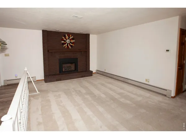 a view of an empty room and kitchen