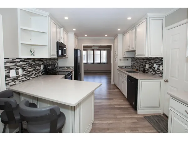 a kitchen with stainless steel appliances a stove a sink a microwave a refrigerator and cabinets