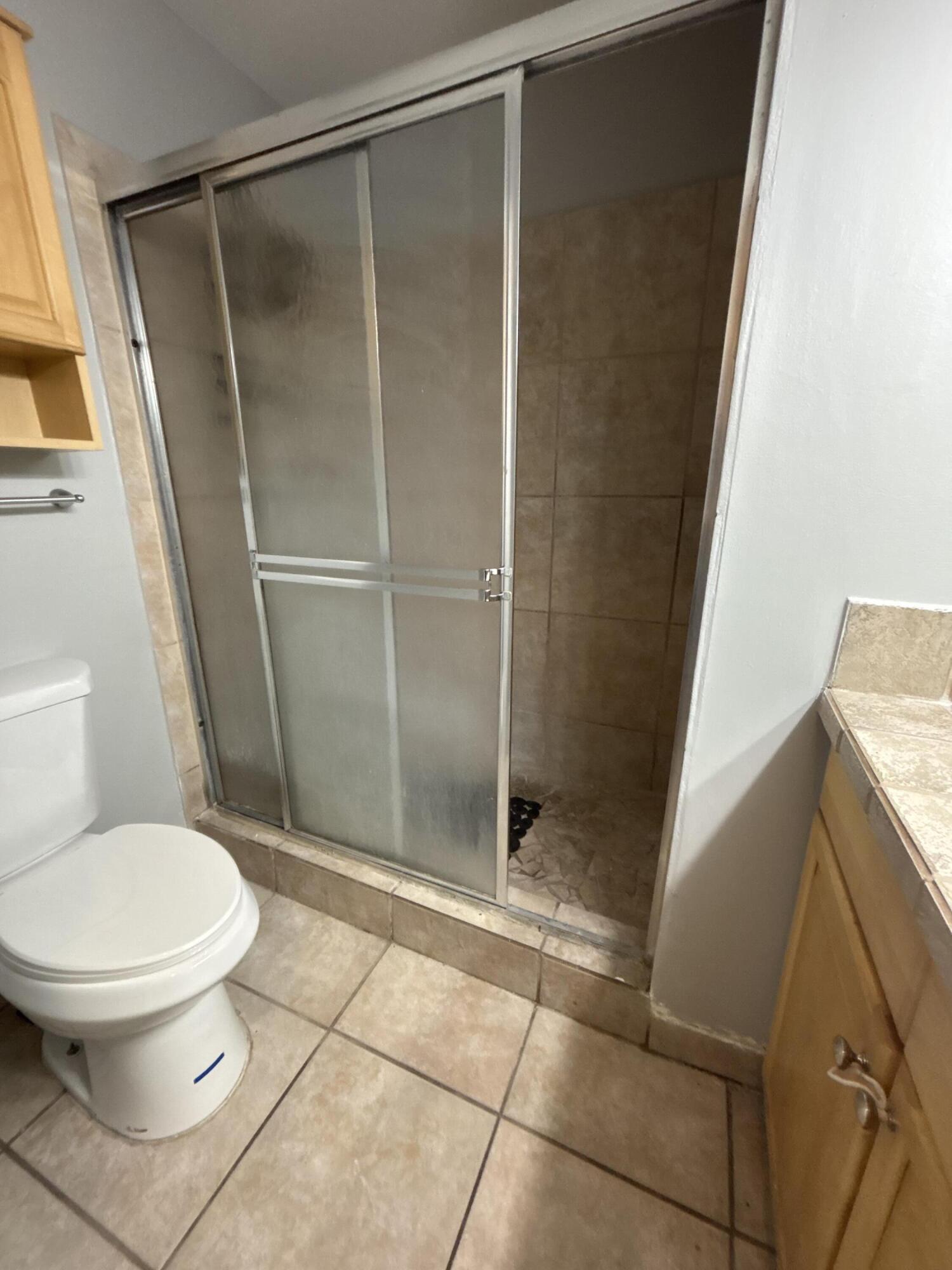 1830 Abbey Road, Unit 105 West Palm Beach, FL 33415 - Photo 11 of 12 a bathroom with a toilet and a shower