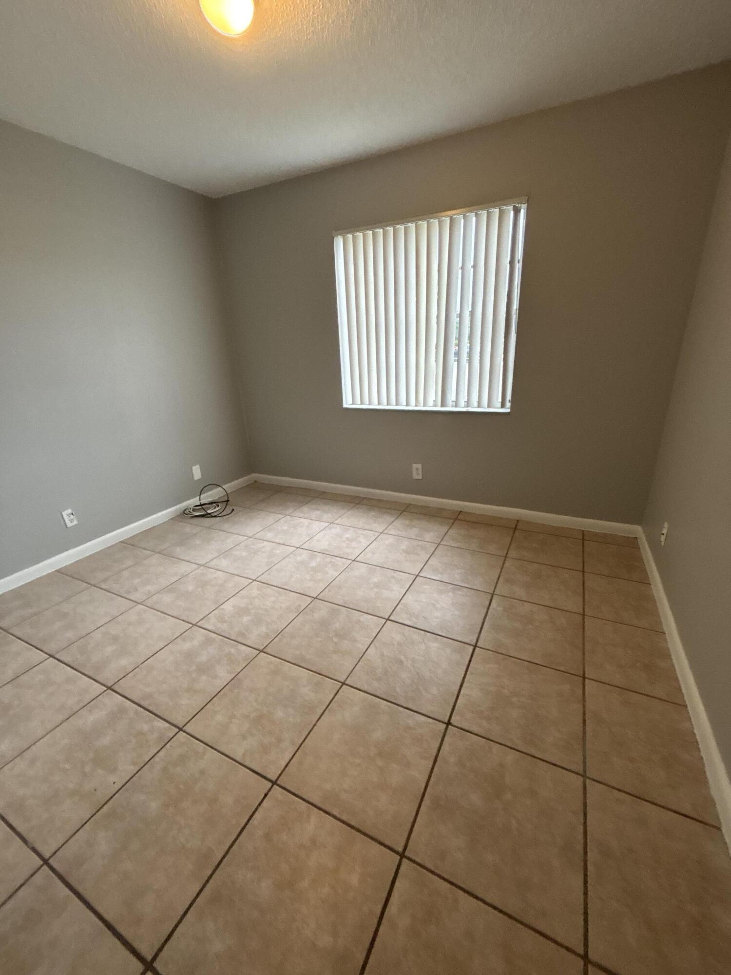 1830 Abbey Road, Unit 105 West Palm Beach, FL 33415 - Photo 9 of 12 an empty room with windows