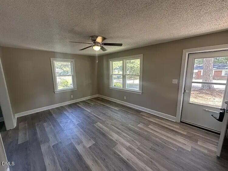 902 Meadow Street South Wilson, NC 27893 - Photo 3 of 10 an empty room with wooden floor and windows