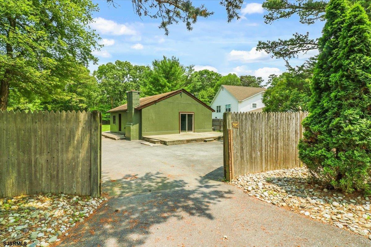 401 Clarkstown Road Mays Landing, NJ 08330 - Photo 27 of 57 a view of a wooden house with a large tree and wooden fence