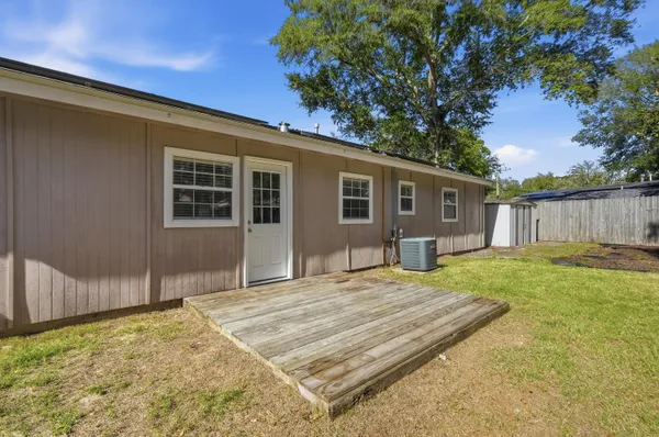 a view of a house with a backyard and a tree