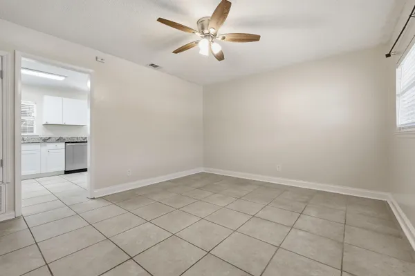 an empty room with windows and fan