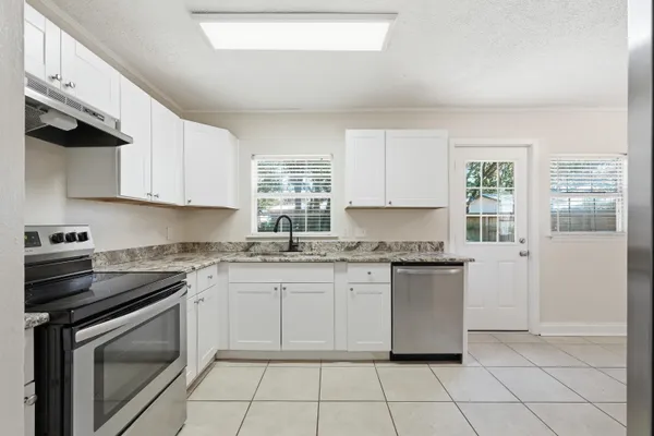 a kitchen with stainless steel appliances granite countertop a stove a sink and a refrigerator