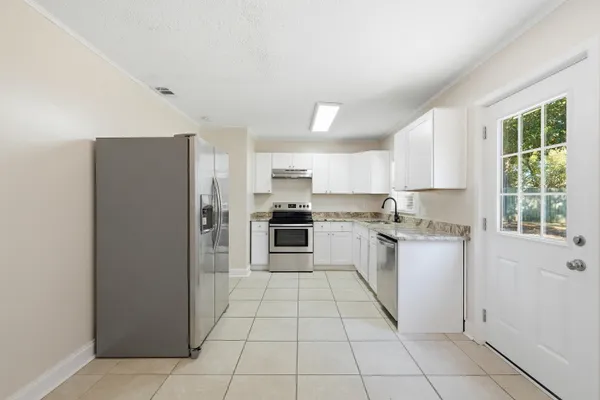 a kitchen with a sink a counter top space and stainless steel appliances