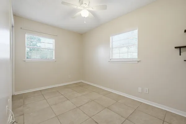 an empty room with a chandelier fan