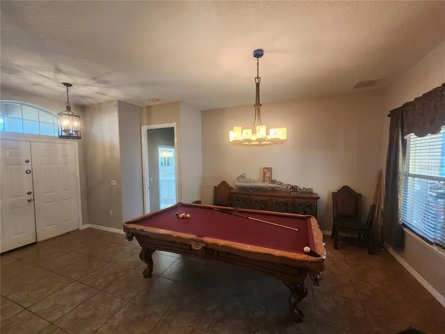 a room with pool table and windows