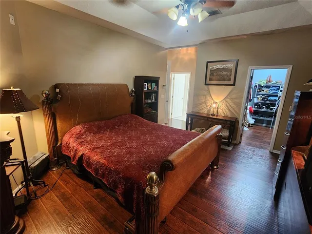 a bed sitting in a bedroom next to a lamp with wooden floor