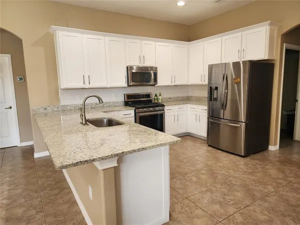 a kitchen with a sink a refrigerator and cabinets