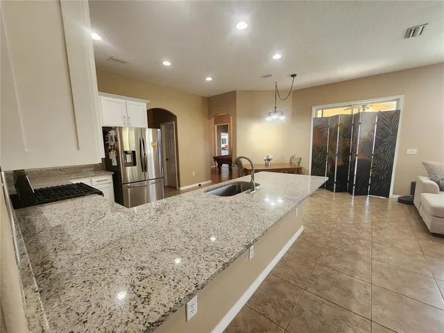 a bathroom with a granite countertop sink and a large mirror
