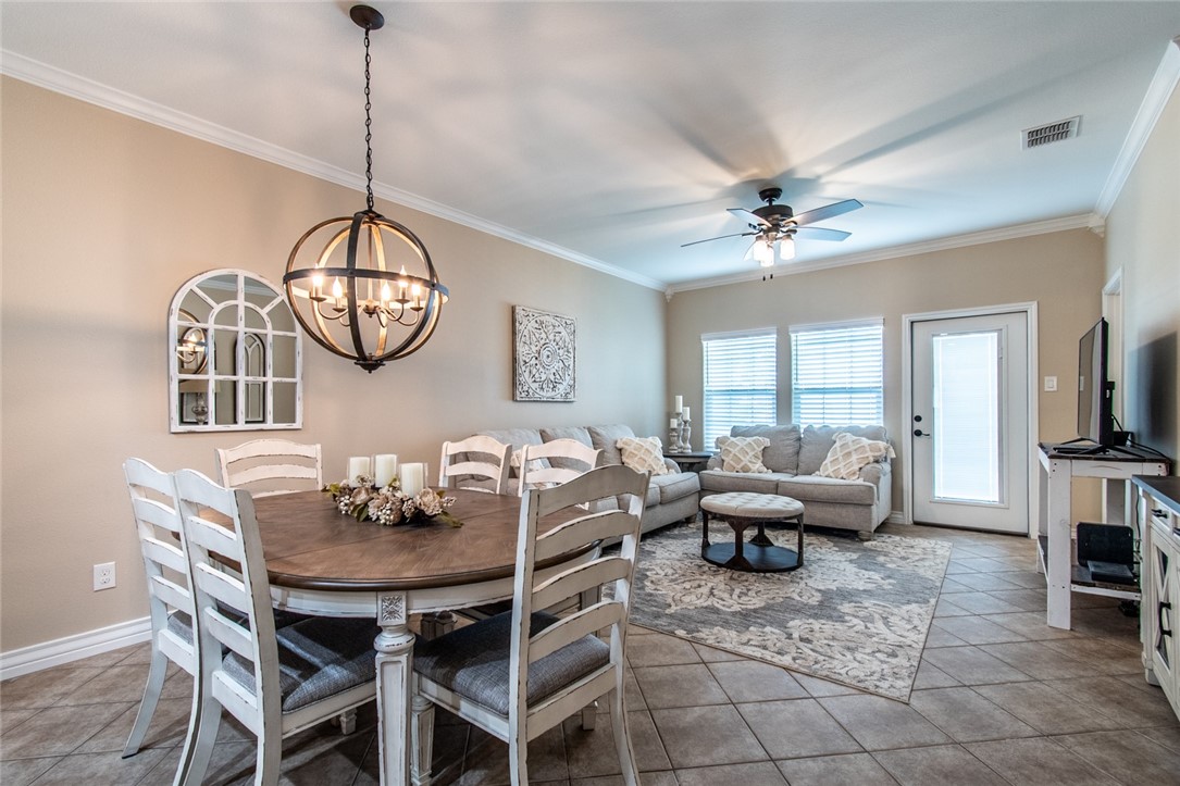 1117 Ninth Street, Unit 803 Port Aransas, TX 78373 - Photo 11 of 27 a living room with furniture a chandelier a rug and a window