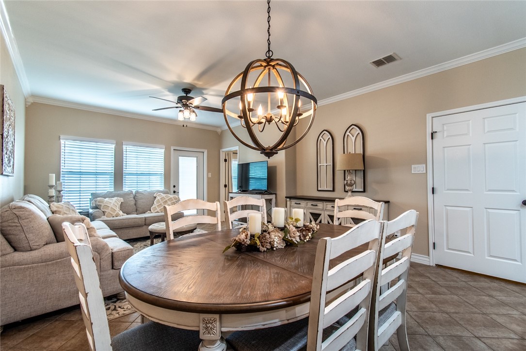 1117 Ninth Street, Unit 803 Port Aransas, TX 78373 - Photo 12 of 27 a living room with furniture a large window and a chandelier