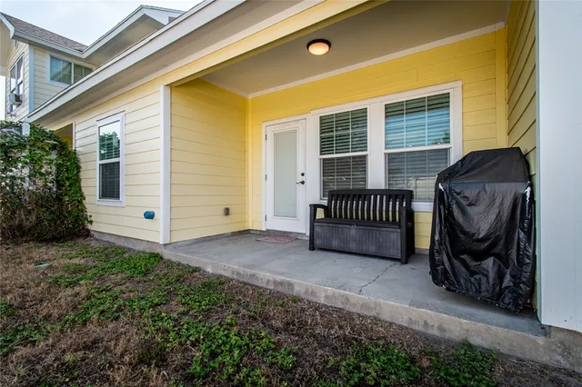 a view of a chair and table in back yard of the house