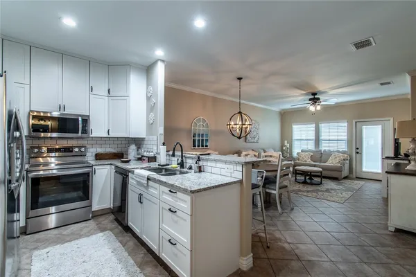 a kitchen with sink stove and cabinets