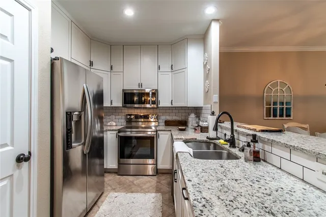 a kitchen with stainless steel appliances granite countertop a refrigerator sink and stove