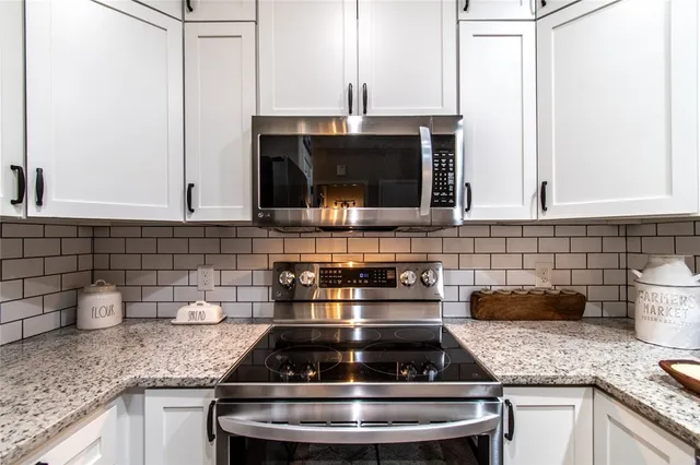 a kitchen with granite countertop a stove sink and cabinets