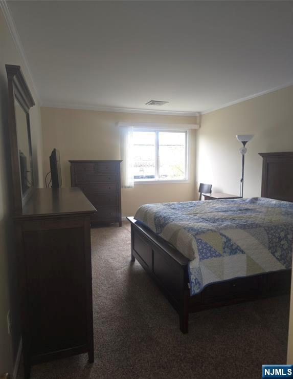 289 Valley Boulevard, Unit 1A Wood-Ridge, NJ 07075 - Photo 14 of 17 a bedroom with a bed and a dresser next to a window