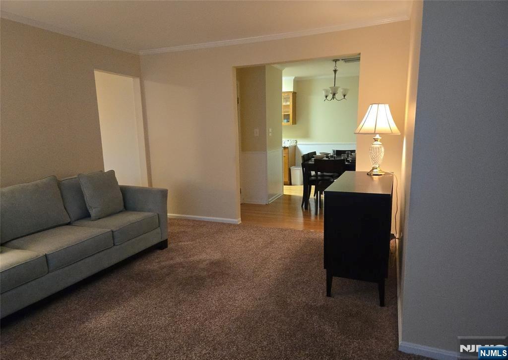 289 Valley Boulevard, Unit 1A Wood-Ridge, NJ 07075 - Photo 4 of 17 a living room with furniture and a chandelier