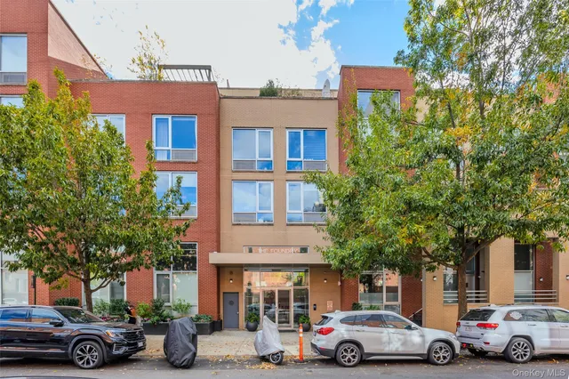 a front view of a building with cars parked