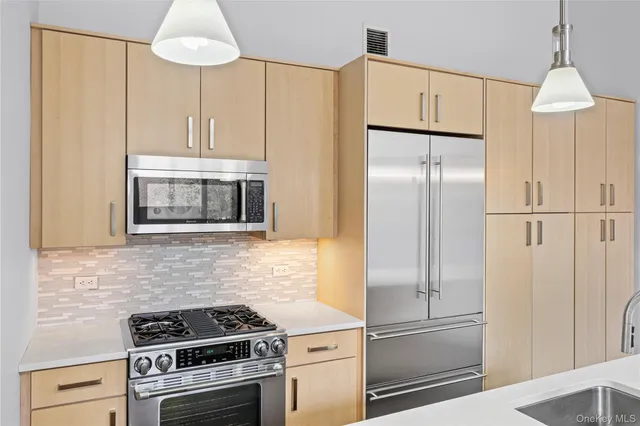 a kitchen with appliances a refrigerator and cabinets