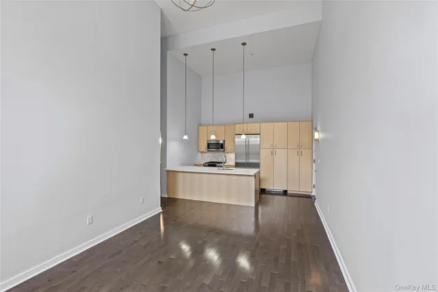 a kitchen with a refrigerator and white cabinets