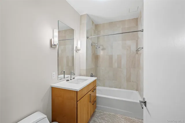 a bathroom with a tub sink shower and a mirror