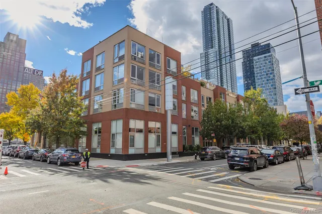a view of a building and car parked on the side of road
