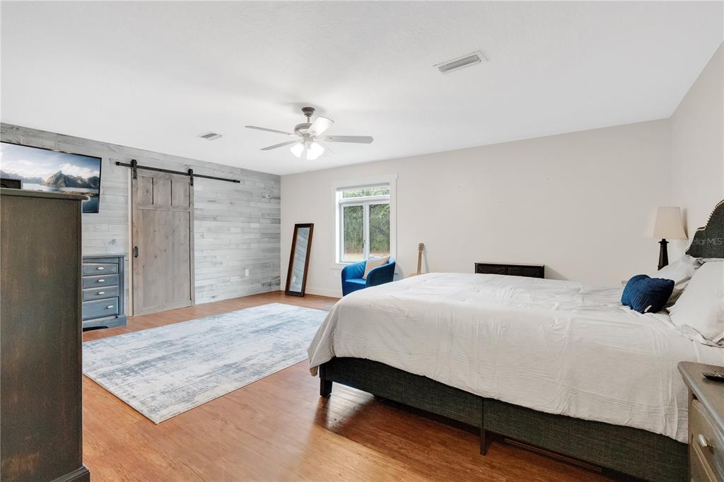 4410 Mildred Bass Road St. Cloud, FL 34772 - Photo 11 of 42 a bedroom with a bed and a chandelier