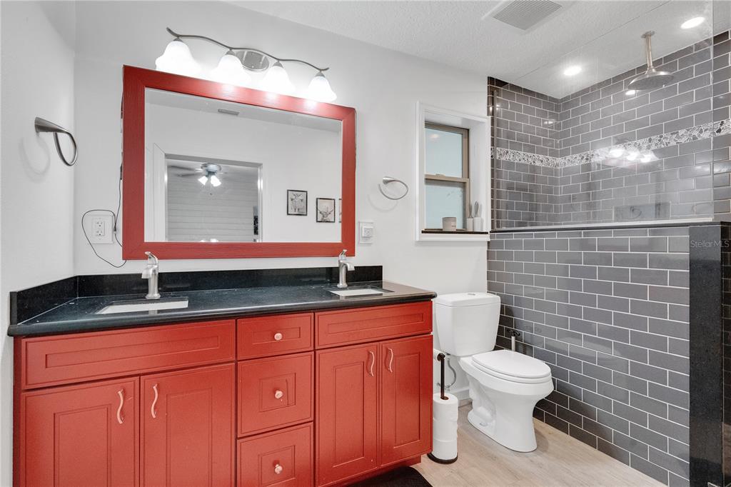 4410 Mildred Bass Road St. Cloud, FL 34772 - Photo 14 of 42 a bathroom with a granite countertop sink mirror and toilet