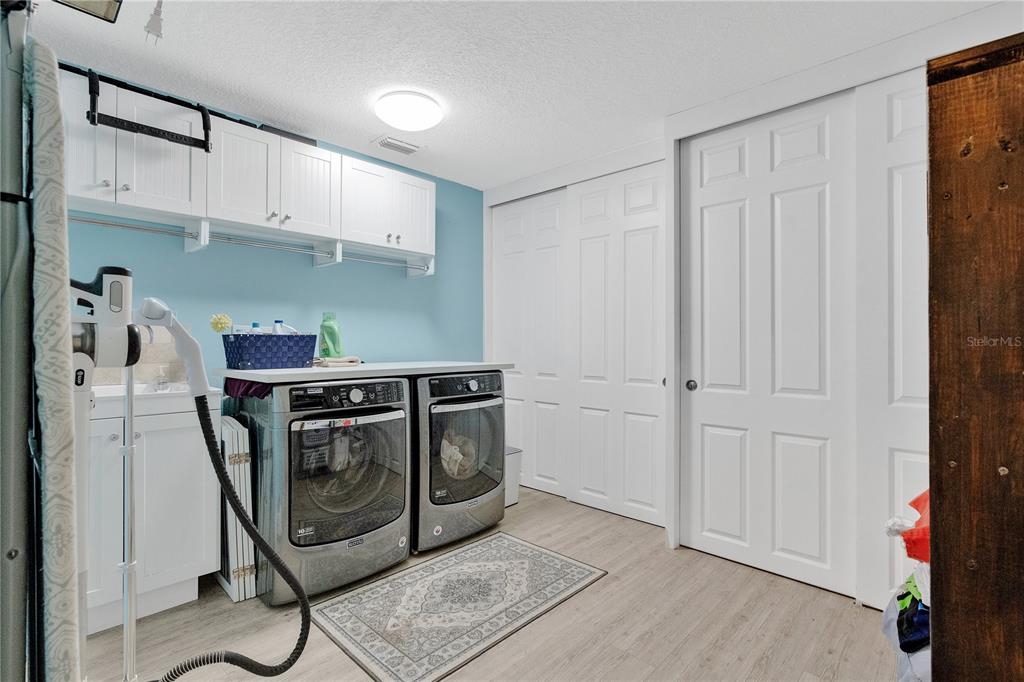 4410 Mildred Bass Road St. Cloud, FL 34772 - Photo 18 of 42 a utility room with stainless steel appliances wooden floor and cabinets
