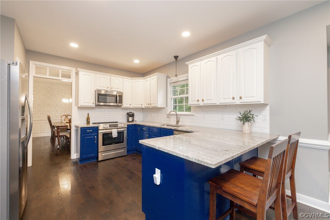 15725 Fox Marsh Drive Moseley, VA 23120 - Photo 12 of 50 a kitchen with a refrigerator a stove top oven a sink dishwasher and wooden cabinets with wooden floor