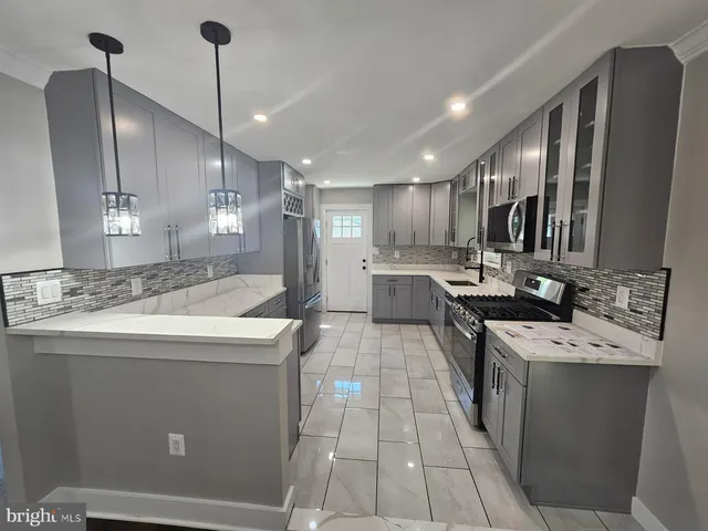 a kitchen with kitchen island stainless steel appliances a sink a counter top space appliances and cabinets