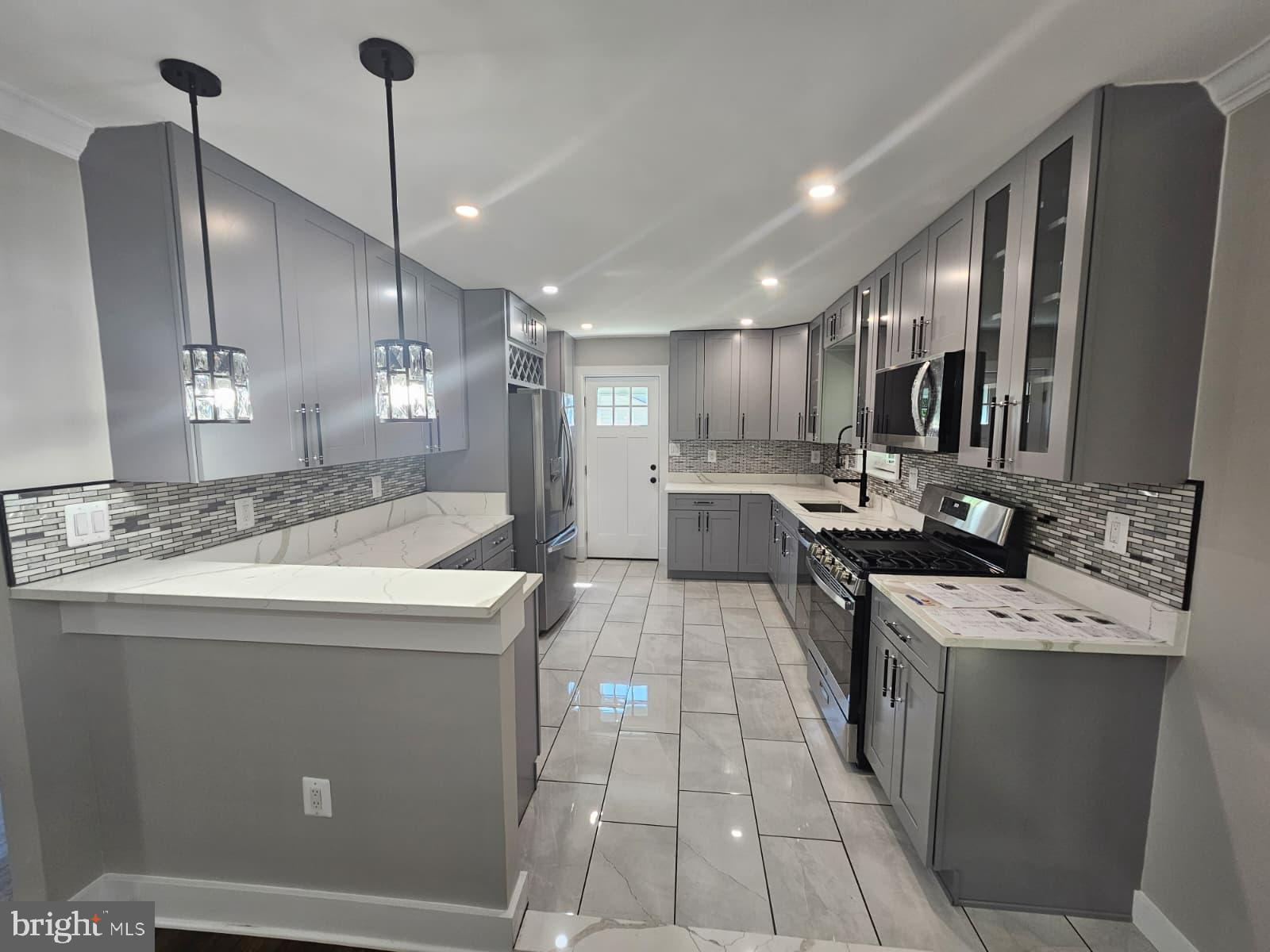 2909 Chapelview Drive Silver Spring, MD 20904 - Photo 15 of 39 a kitchen with kitchen island stainless steel appliances a sink a counter top space appliances and cabinets