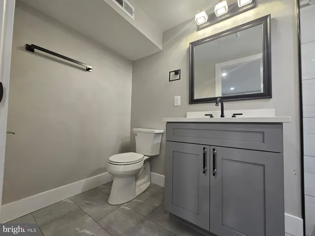 a bathroom with a toilet sink and mirror