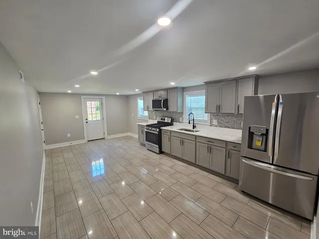 a kitchen with stainless steel appliances granite countertop a refrigerator sink and cabinets