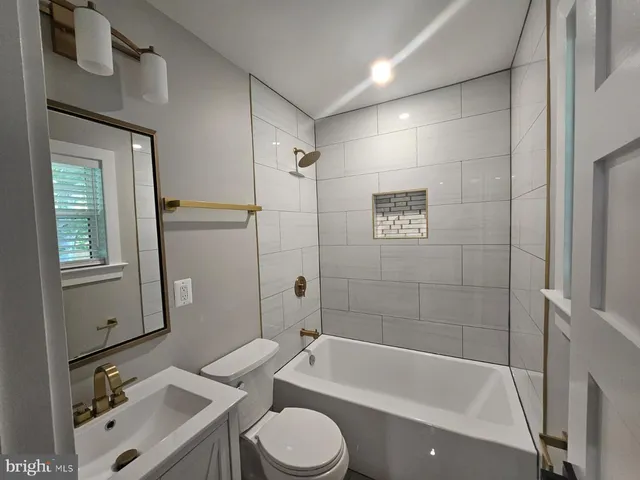 a bathroom with a sink mirror bathtub and toilet
