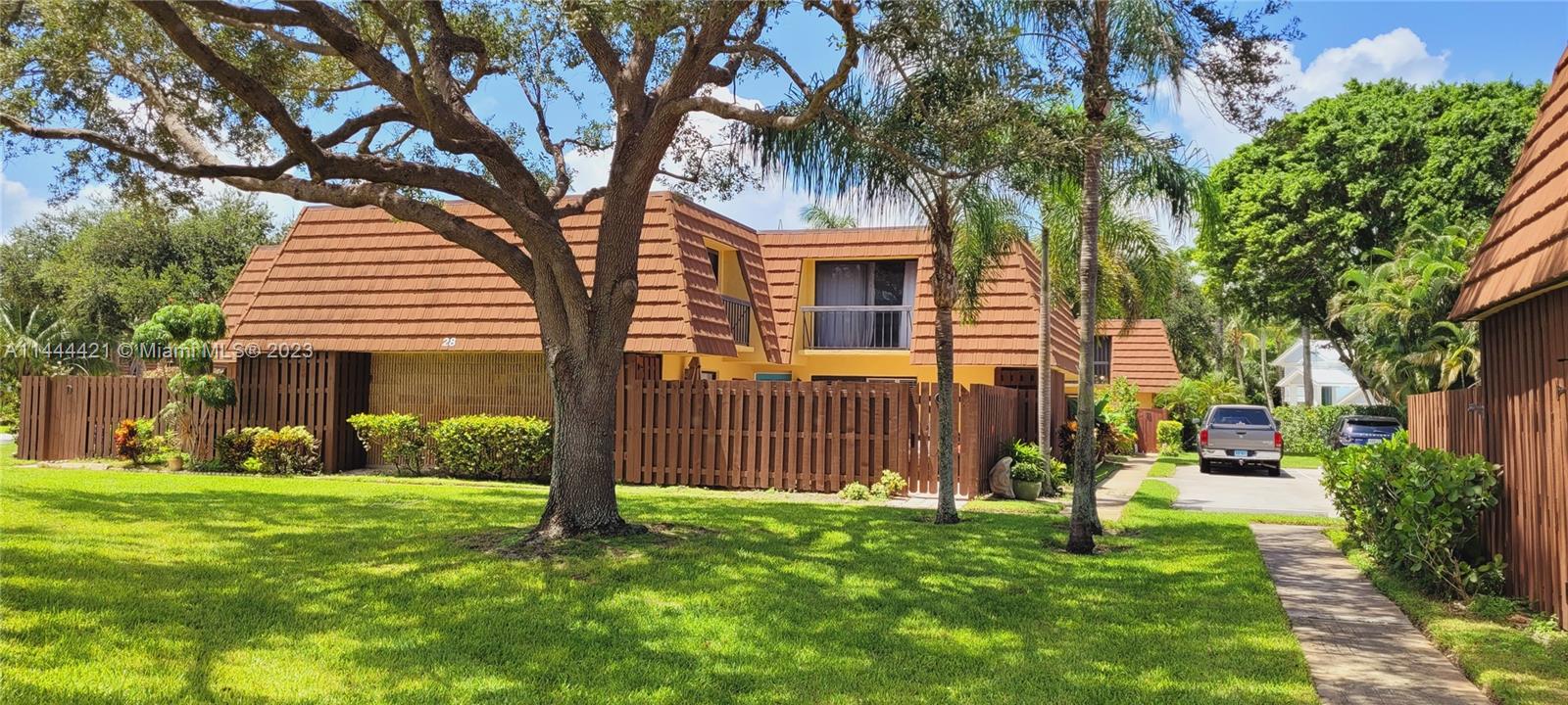 825 Center Street, Unit 28C Jupiter, FL 33458 - Photo 5 of 29 a front view of a house with a garden and tree